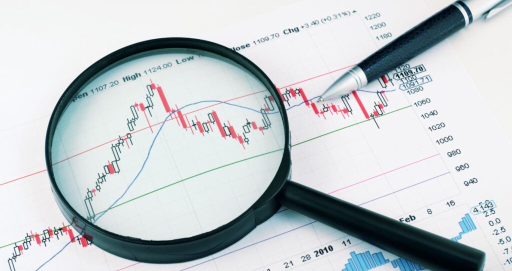 ETFs on a graph showing profits with a magnifying glass and a pen on top