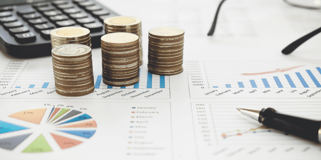 investments and money on top of graphs and spreadsheets