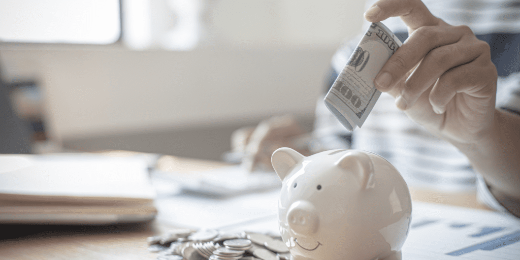 woman putting cash in a piggy bank