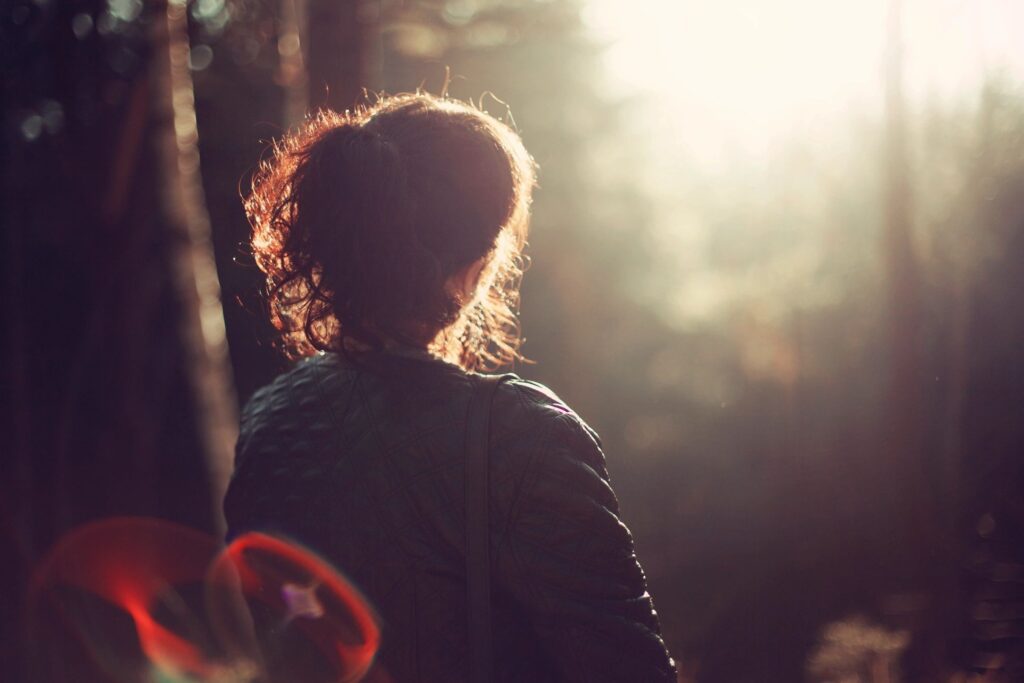 woman looking at the sunset in a forest