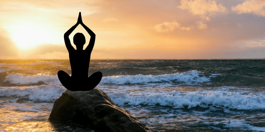 woman meditating by the beach