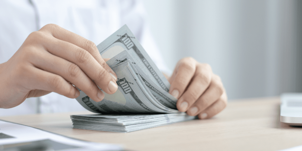 woman counting 100 dollar bills